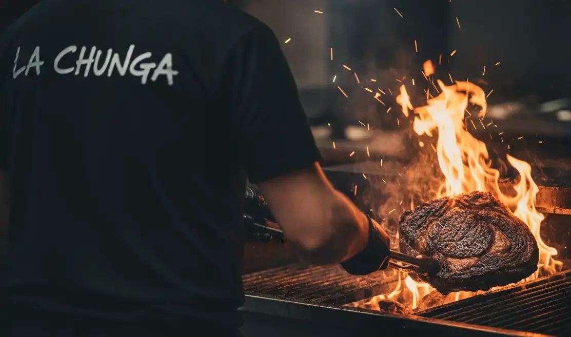 Le grilladin de La Chunga saisit une côte de bœuf dans les flammes