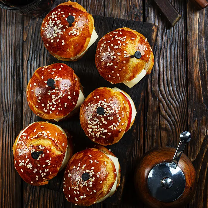 Mini burgers briochés au sésame, servis pour un cocktail